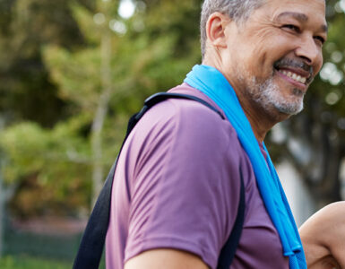 A middle-aged man and woman standing together outdoors after a workout.