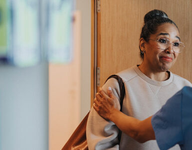 A black woman talking to a surgeon in a clinical setting.