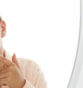 women looking in the mirror at her chin