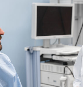 A man in his 40s prepping with his doctor in the medical room before getting a colonoscopy.