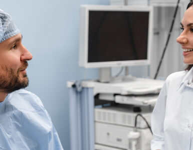 A man in his 40s prepping with his doctor in the medical room before getting a colonoscopy.