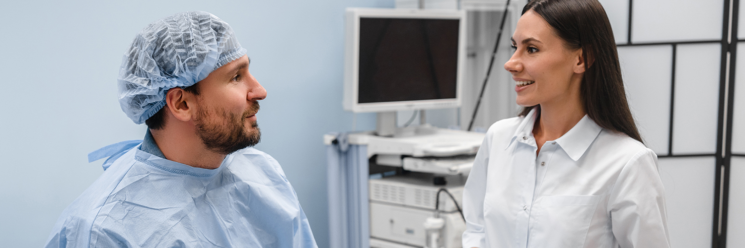 A man in his 40s prepping with his doctor in the medical room before getting a colonoscopy.