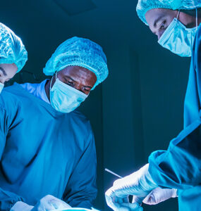 Three surgeons in the OR performing heart valve surgery.