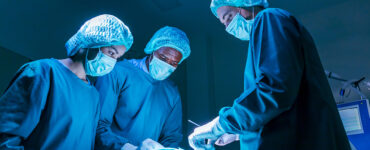 Three surgeons in the OR performing heart valve surgery.