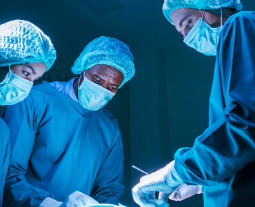 Three surgeons in the OR performing heart valve surgery.