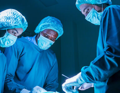 Three surgeons in the OR performing heart valve surgery.