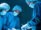 Three surgeons in the OR performing heart valve surgery.