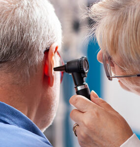 A doctor checking older man's hearing