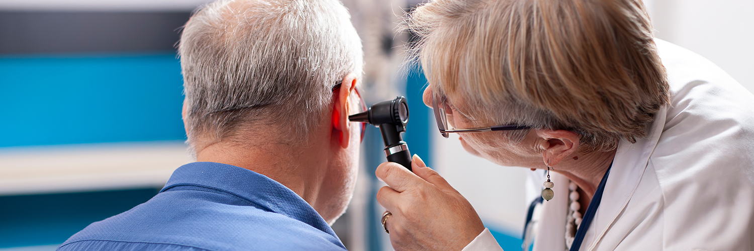 A doctor checking older man's hearing