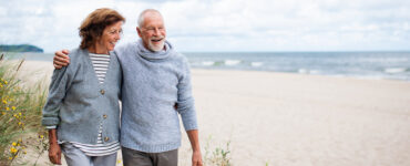 older couple walking on the beach