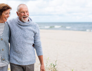 older couple walking on the beach