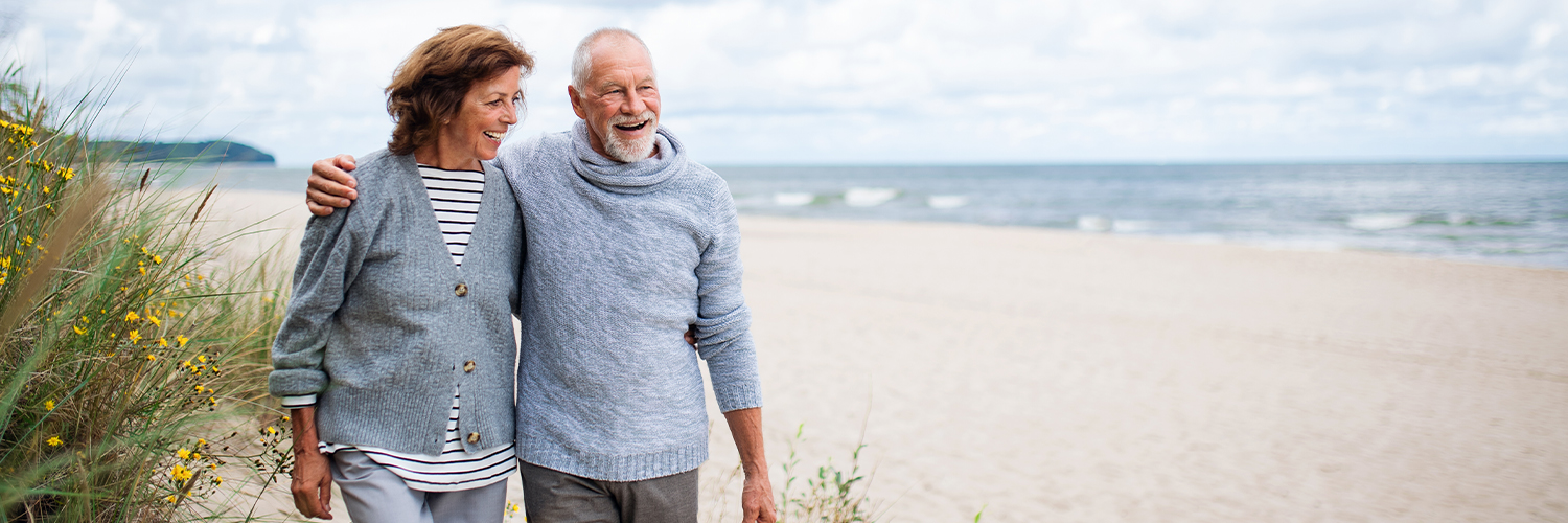 older couple walking on the beach