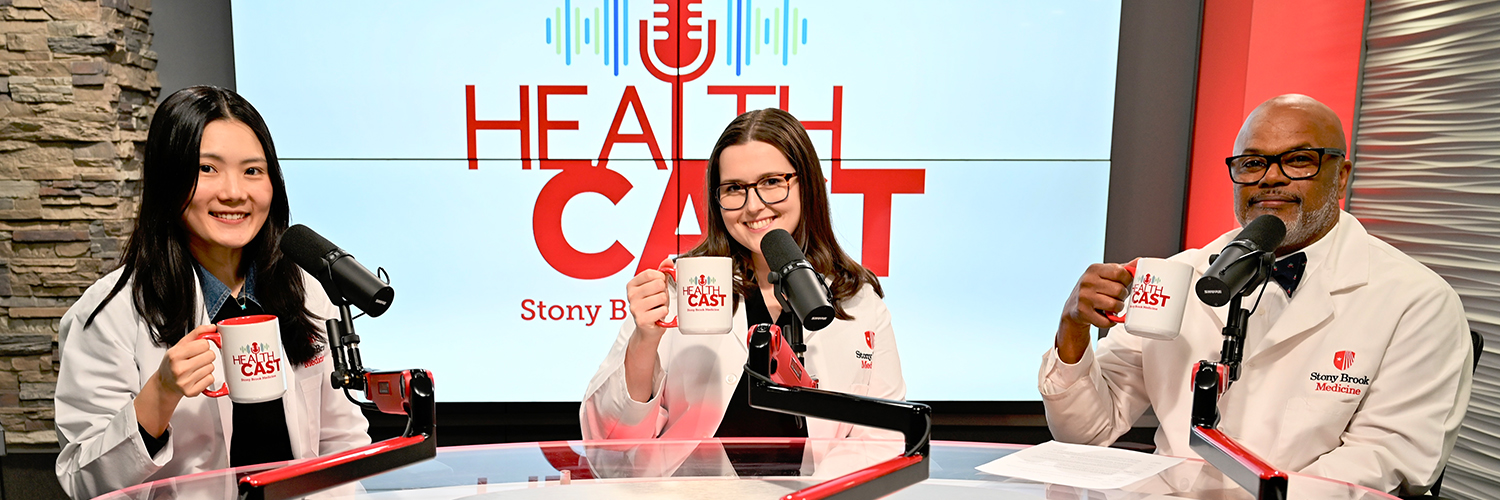 Three physicians from Stony Brook Medicine sitting in the podcast video, holding up coffee mugs and smiling.
