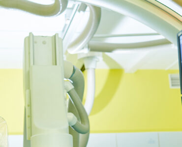 Interventional radiologist looking at computer with imaging scans