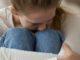 Teenage girl sitting on couch having panic attack