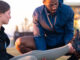 Sports therapist massaging the leg of a female athlete outdoors