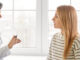 Supporting caring female doctor consulting young woman patient