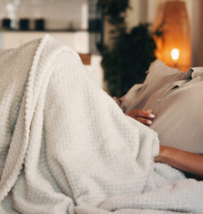 Woman on the couch with a stomach ache.