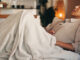 Woman on the couch with a stomach ache.