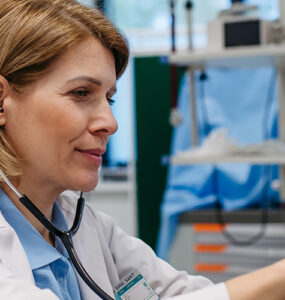 Doctor checking elderly female patient's heart.