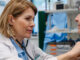 Doctor checking elderly female patient's heart.