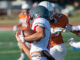 Three teenage football players running a play.