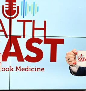 Experts from Stony Brook Medicine sitting in the podcast studio, holding up coffee mugs and smiling.