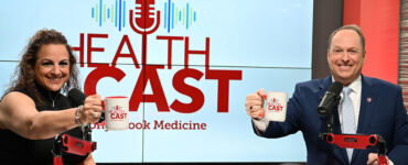 Experts from Stony Brook Medicine sitting in the podcast studio, holding up coffee mugs and smiling.