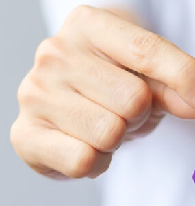 A hand holding up a purple ribbon for overdose awareness month.