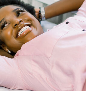 Happy smiling pregnant African American woman getting ultrasound from doctor at her prenatal appointment.