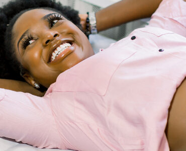 Happy smiling pregnant African American woman getting ultrasound from doctor at her prenatal appointment.