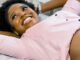 Happy smiling pregnant African American woman getting ultrasound from doctor at her prenatal appointment.