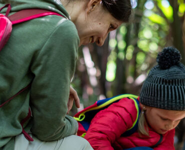 family hiking in the woods stopped to inspect something.