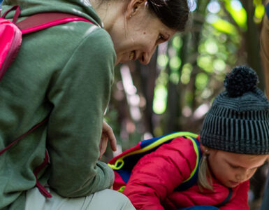 family hiking in the woods stopped to inspect something.