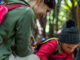 family hiking in the woods stopped to inspect something.