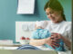 young woman sitting in hospital bed holding and breastfeeding newborn baby