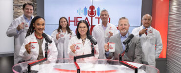 Experts from Stony Brook Medicine together in the podcast studio, holding branded coffee mugs.