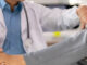 A doctor is helping a patient with a foot injury. The patient is wearing a gray and white outfit.