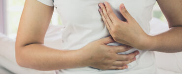 Woman with burning in the chest suffering from indigestive problem.